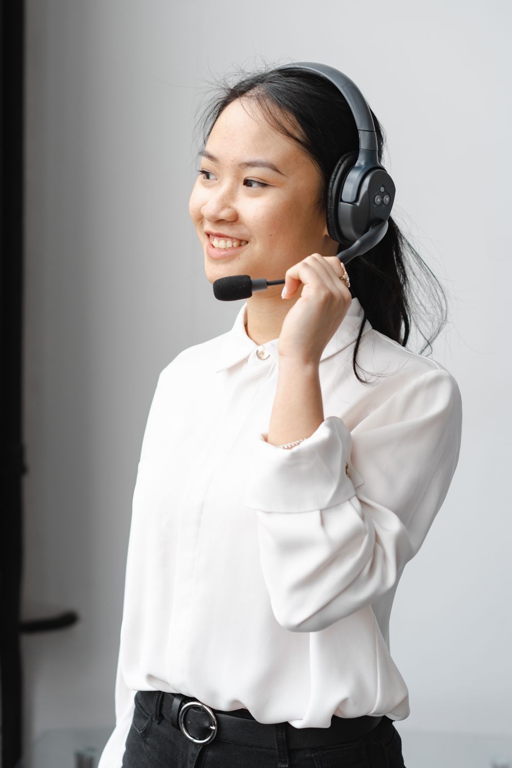 A TeleThai agent wearing a headset, smiling